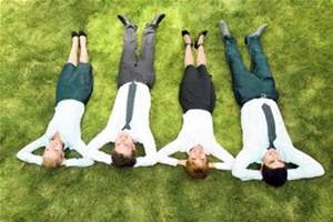 four people lying down in the grass